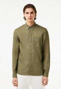 Camicia a maniche lunghe di colore verde oliva, realizzata in tessuto leggero, con taschino sul petto e piccolo logo ricamato sul lato sinistro.