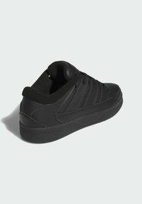 Scarpa da corsa nera con design a basse, realizzata in pelle liscia, presenta strisce laterali testurizzate, collo imbottito e suola in gomma.