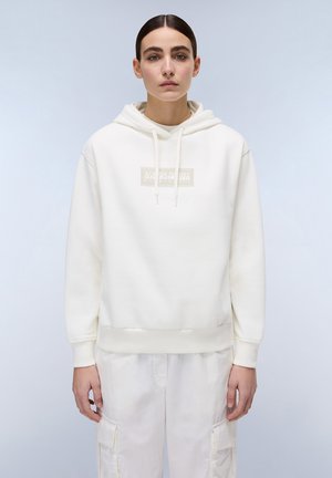 Witte hoodie gemaakt van zacht stof, met een logo patch aan de voorkant, ribgebreide manchetten en zoom, gecombineerd met lichtgekleurde cargobroek.