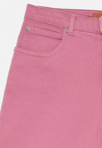 Rosa denimbukser med en glatt tekstur, som har en standard fem-lommers design og metalliske knappdetaljer foran.