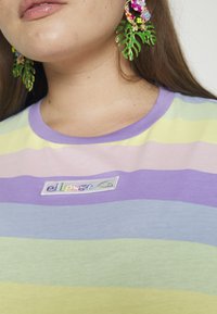 T-shirt à manches courtes rayé dans des couleurs pastel (lavande, vert, jaune) avec un col rond et un logo brodé.