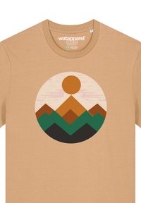 Beige katoenen T-shirt met een circulaire grafiek van gelaagde bergen in oranje, groen en zwart, met een zonsondergang op de achtergrond.