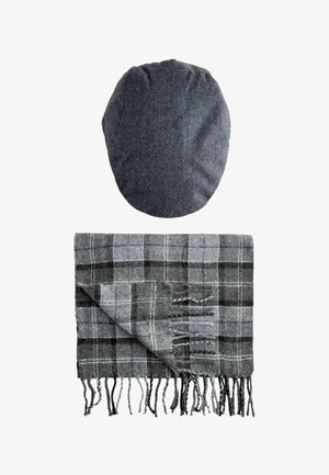 Pelēks herringbone raksta cepure virs pelēka plaid šalles ar melnbaltiem akcentiem, ar frizētām malām un mīkstu tekstūru.