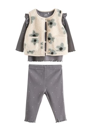 Conjunto infantil que incluye un chaleco de forro polar color crema con patrones florales en negro y verde, una camiseta gris acanalada con mangas con volantes y leggings a juego con el mismo estampado.