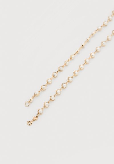 Collier chaîne ton or avec des perles rondes réparties régulièrement sur toute la longueur, doté d'un fermoir sécurisé et de maillons délicats.