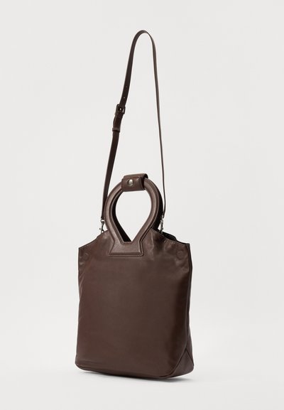 Borsa a tracolla in pelle marrone con un design unico della maniglia ovale, tracolla regolabile e texture liscia. Presenta accenti hardware minimi.