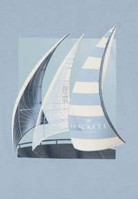 L'image présente trois voiles de voiliers, deux courbées et une rayée. Les voiles sont dans des nuances de bleu, avec "HACKETT LONDON" imprimé de manière proéminente.