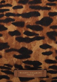 Cuoio a stampa leopardata con diverse sfumature di marrone e macchie nere. Presenta un'etichetta marrone con la scritta "GIANNI CHIARINI FIRENZE" in rilievo.