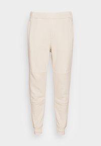 Beige joggings met een taps toelopende pijp, elastische tailleband, zijzakken en gestikte paneeldetails. Gemaakt van zachte, comfortabele stof.