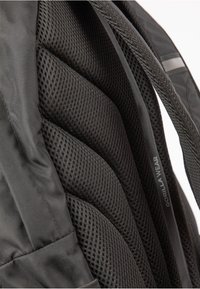 Black backpack featuring padded mesh material, ergonomic design, and textured compartments for ventilation. "GORILLA WEAR" label visible.
