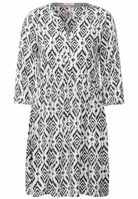 Robe à motifs noir et blanc avec un décolleté en V, des manches trois-quarts et une taille froncée. Présente un motif géométrique sur l'ensemble.