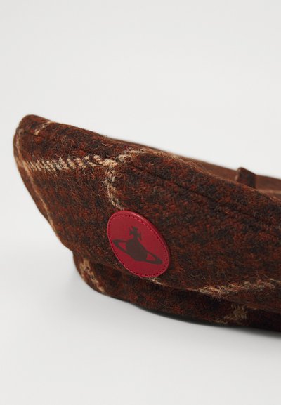 Brown wool cap with a textured finish, featuring a red logo patch and subtle light brown stitching accents.