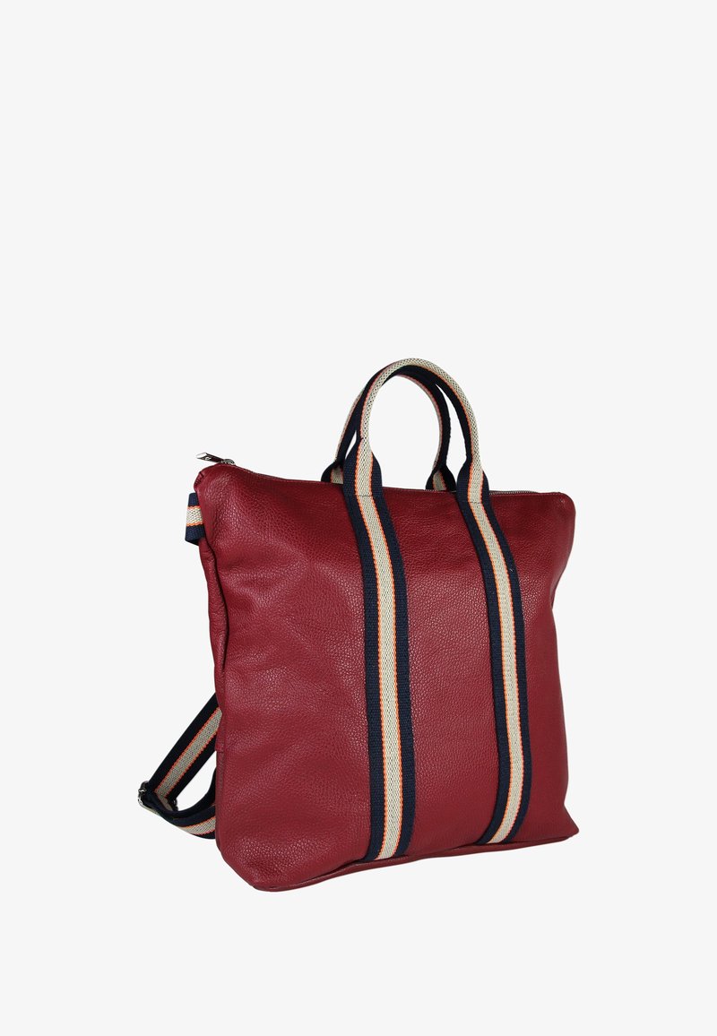 Rode leren tote bag met dubbele gestreepte stoffen handvatten en schouderbanden in marineblauw, wit en oranje, weergegeven tegen een witte achtergrond.