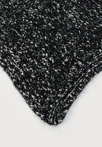 Fekete-fehér mélázott kötött anyag bordázott textúrával, részletes közeli kép az anyag sarkáról.