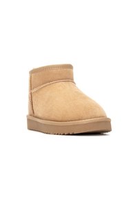 Botas de tobillo de gamuza color tostado con una altura baja, textura suave, puntera redondeada y suela de goma estriada; presenta un sencillo detalle de costura.