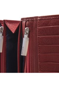 Portafoglio in pelle rossa con diversi scomparti per carte, compartimenti con zip e dettagli in metallo argentato. L'interno presenta un rivestimento di colore blu scuro.