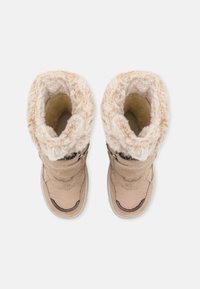 Beige téli csizmák műszőrme béléssel és pántos záródással. Puha textil külső, lekerekített orr és strukturált gumitalp.