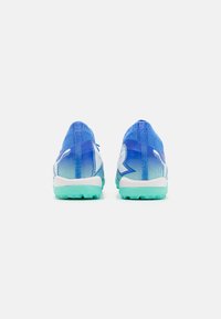 Zapatillas deportivas azules con un diseño degradado, que presentan un material superior de malla y una suela turquesa. Los acentos incluyen detalles de marca en blanco.