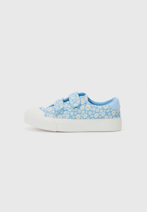 Baskets en toile bleu clair avec semelle en caoutchouc blanche, arborant un motif floral de petites marguerites et des bandes Velcro pour la fermeture.
