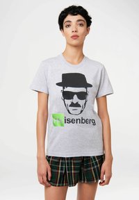 Gray cotton t-shirt featuring a black graphic of a man in a hat and sunglasses, with the text "Heisenberg" in green below.