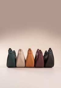 Sechs Handtaschen in einer Reihe, aus strukturiertem Leder in Grün, Beige, Orange, Bordeaux und Schwarz, mit klaren Formen und goldenen Akzenten.