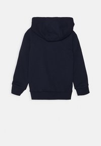 Navyblauwe capuchontrui. Zachte, gestructureerde stof met geribbelde manchetten en zoom. Achteraanzicht zonder zichtbare logo's of patronen.