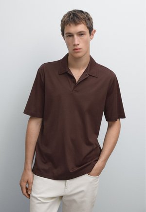 Brown short-sleeve polo shirt with a pointed collar, made of a smooth fabric, featuring two button plackets, paired with light-colored pants.