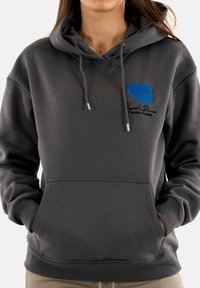 Felpa in cotone grigio scuro con tasca a filetto sul davanti, coulisse e logo a forma di cuore blu con testo nero sul petto.