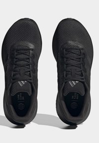 Czarne buty sportowe z siateczkową cholewką, płaskimi sznurówkami i teksturowaną podeszwą. Posiadają logo w postaci trzech pasków oraz metkę "End Plastic Waste" wewnątrz.