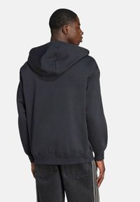 Black hooded sweatshirt with a relaxed fit, soft texture, and ribbed cuffs. Features a kangaroo pocket and a simple design.