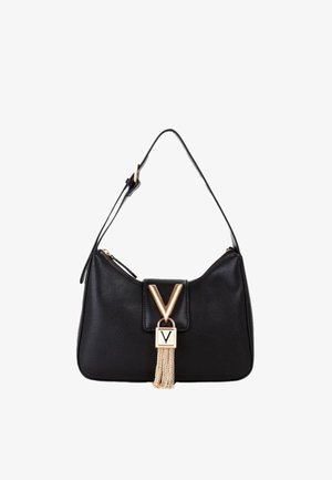 Bolso de hombro de cuero negro con un cierre en forma de V en tono dorado, detalle de borla de cadena y correa ajustable. Diseño simple y curvado.