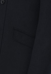 Czarny wełniany płaszcz z pojedynczym zapięciem na guzik, teksturowanym materiałem i kieszenią wpuszczaną. Projekt podkreśla czyste linie i minimalne detale.