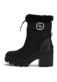 Bottine noire à talon épais, avec un revers en fourrure synthétique, un badge en rhinestone, une semelle robuste et un cordon de serrage ajustable en haut.