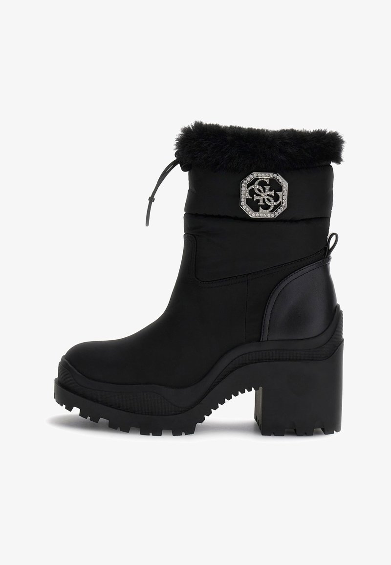 Bottine noire à talon épais, avec un revers en fourrure synthétique, un badge en rhinestone, une semelle robuste et un cordon de serrage ajustable en haut.