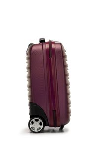 Hard-shell suitcase in deep purple, featuring textured surface, black accents, and a sturdy handle. Equipped with smooth-rolling wheels.