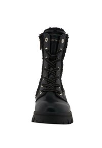 Stivali neri alla caviglia con una finitura lucida, foderati in pelliccia e con occhielli metallici. Presentano una suola spessa e strutturata e cuciture decorative.