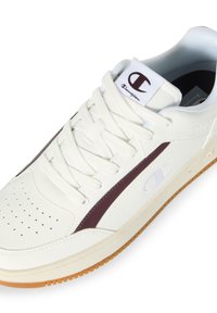 Weiße Leder-Sneaker mit kastanienbraunen Akzenten, perforierter Zehenpartie und flachen Schnürsenkeln. Gummisohle und strukturierte Zunge mit Logodetail.