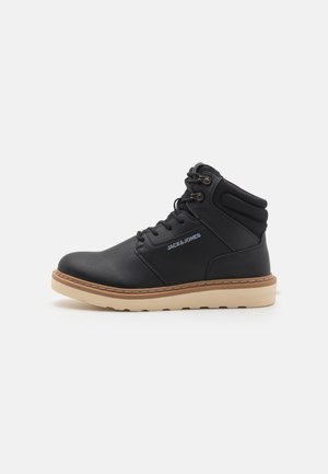 Black Jack & Jones High-Top-Stiefel mit gepolstertem Knöchelbereich, Schnürung vorne und beiger Sohle, seitliche Ansicht vor weißem Hintergrund.