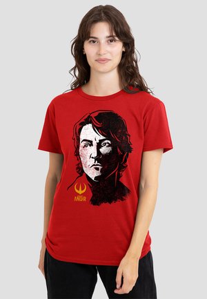Red cotton t-shirt featuring a black and white graphic of a face, with a yellow "ANDOR" text and emblem below the image.