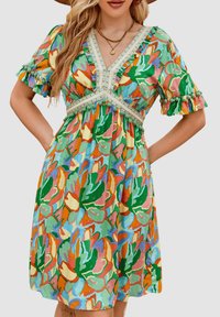 Vestido de manga corta con un vibrante estampado floral en tonos verdes, naranjas y amarillos. Escote en V con borde decorativo y cintura fruncida.