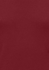 Ribbede, burgunderfarget stoff med en glatt tekstur. Materialet er elastisk og tettsittende, egnet for ulike casual-stiler.