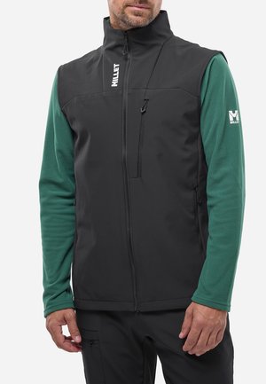 Gilet softshell noir avec col haut, poche zippée à l'avant et chemise longue à manches vertes en dessous. Présente des accents de logo.