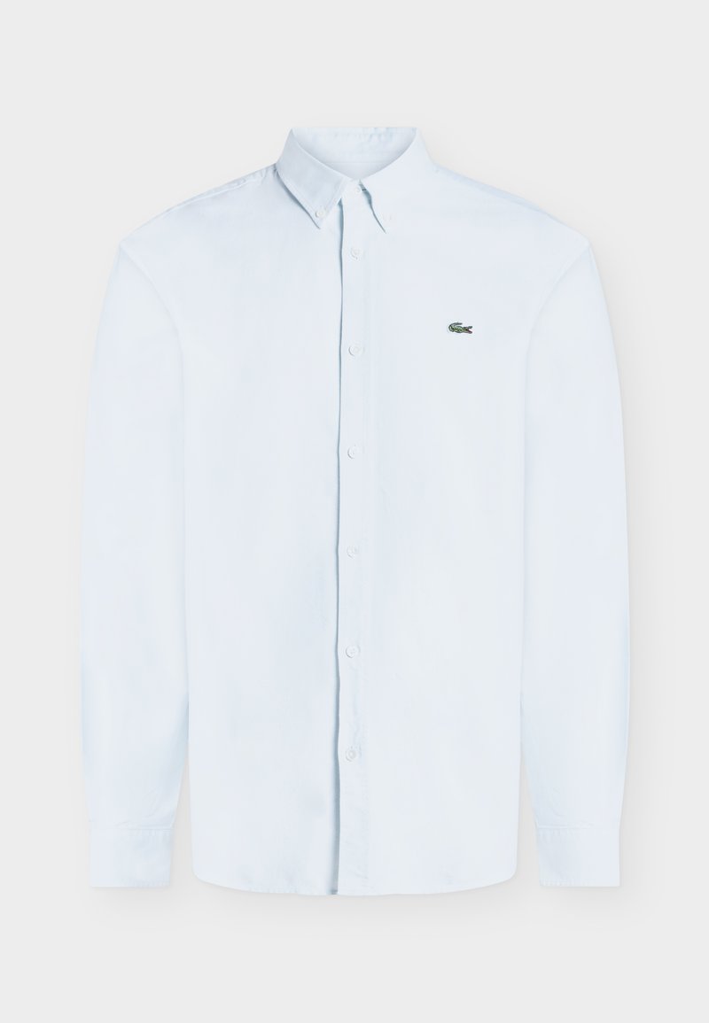 Camicia azzurra chiaro a maniche lunghe con bottoni, colletto con bottoni e piccolo logo verde a coccodrillo sul petto sinistro.