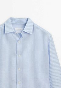 Camicia button-up a righe blu chiaro realizzata in tessuto testurizzato. Presenta un colletto classico e bottoni bianchi lungo il davanti.