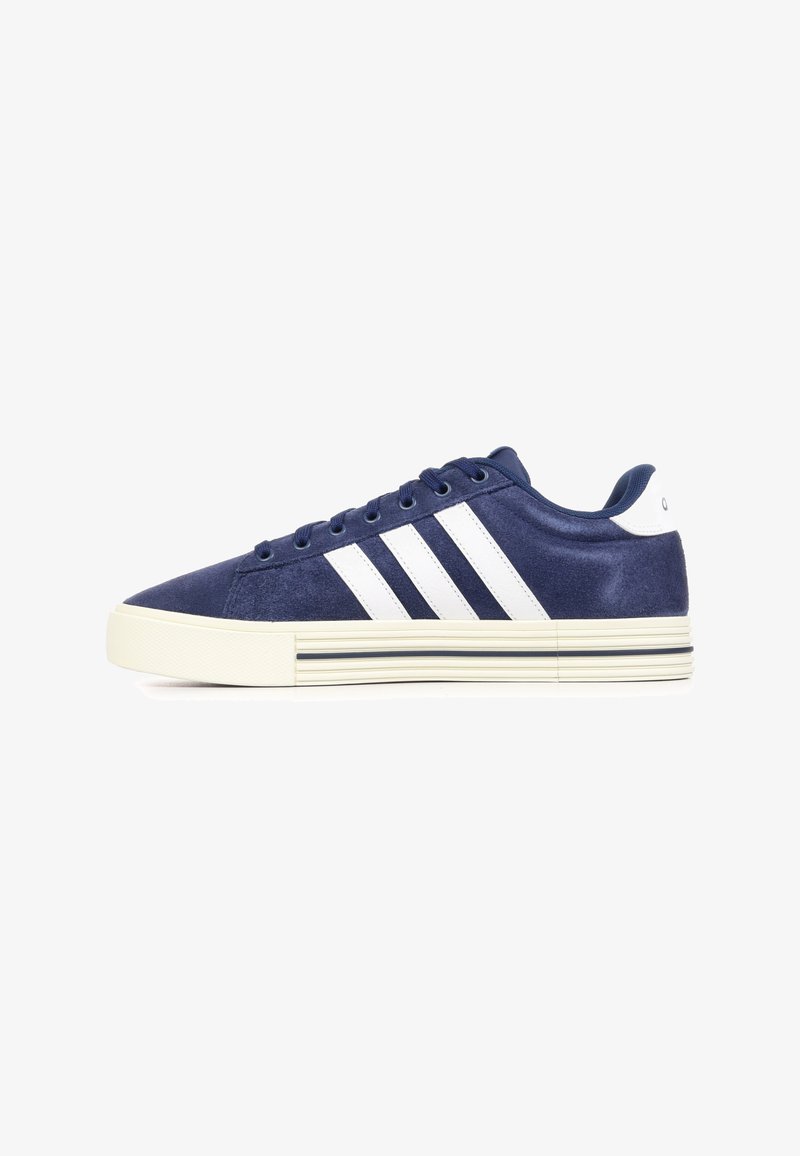 Baskets basses bleu marine avec des bandes blanches et une semelle blanche ornée de fines lignes noires, vues de côté sur fond blanc.