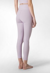 Lila leggings i mjukt, elastiskt material. Hög midja med platta sömmar, som når ankellängd. Minimalistisk design, utan mönster eller detaljer.