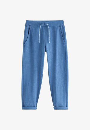 Blå afslappede joggebukser med elastisk talje, hvid snøre, sidelommer og manchetter i bukseenden, lagt fladt på hvid baggrund.