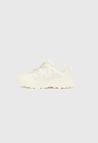 Fehér, vastag talpú sportcipő hálós és bőrpanelekkel, vastag talppal, valamint bungee stílusú fűzőkkel, állítható csattal.