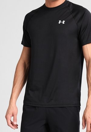 Schwarzes kurzärmeliges Sportshirt mit kleinem weißem Under Armour-Logo auf der linken Brust, getragen von einem männlichen Modell.