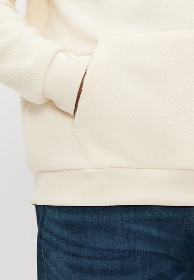 Εκρού φλις φούτερ με τσέπη καγκουρό, ριμπ μανσέτες και τελείωμα. Διαθέτει απαλό, υφασμάτινο ανάγλυφο φινίρισμα και άνετη γραμμή.